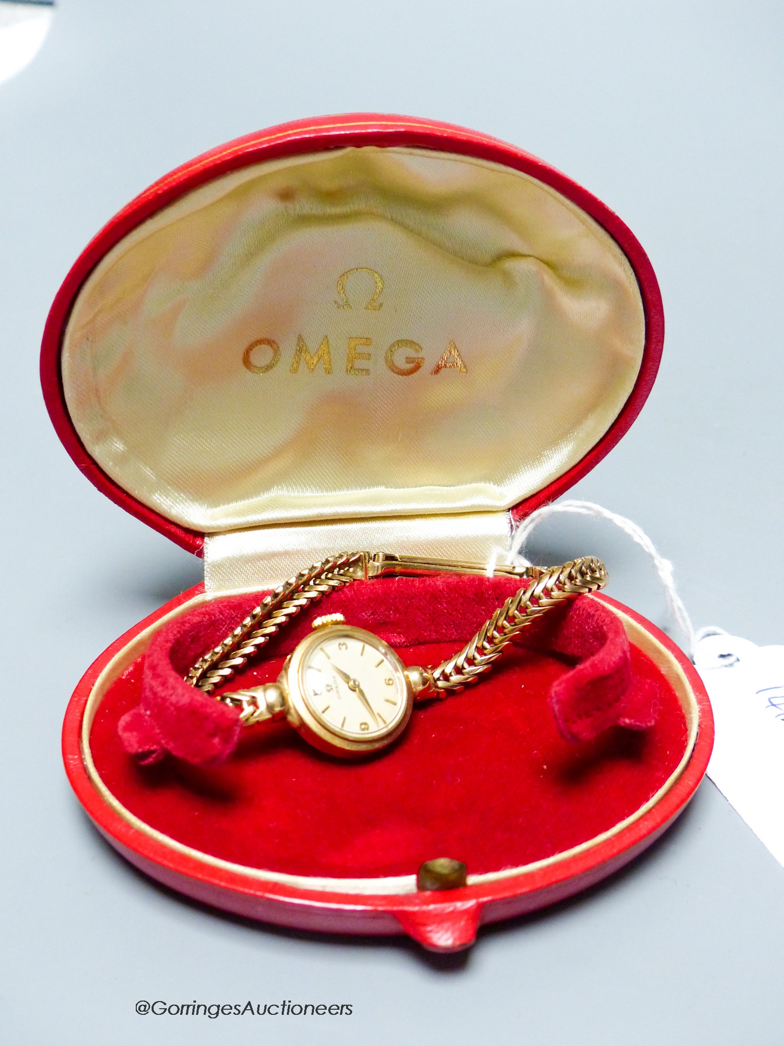 A lady's 9ct gold Omega manual wind wrist watch, on a 9ct gold bracelet, case diameter 20mm, gross 17.6 grams., with Omega box.